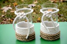 two clear glass vases with rope wrapped around them on a green table in the grass