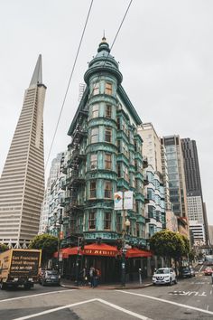 a tall building sitting on the side of a road next to tall buildings and traffic