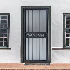 a white building with black windows and bars on the front door is seen in this image