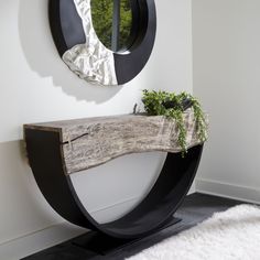 a wooden bench sitting in front of a mirror on the wall next to a white rug