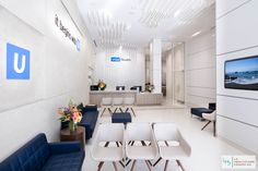 an office lobby with white walls and blue chairs