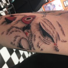 a close up of a person's arm with an owl tattoo design on it