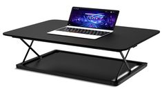 a laptop computer sitting on top of a black table