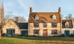 a large brick house sitting on top of a lush green field