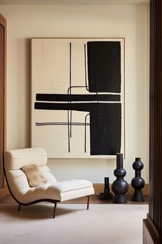 a white chair sitting in front of a black and white painting