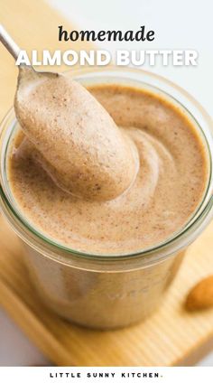 homemade almond butter in a glass jar with a spoon sticking out of it and text overlay that reads homemade almond butter