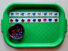 a green tray with hearts and candy on it