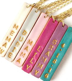 three different colored books are on a gold plated chain that is attached to a necklace