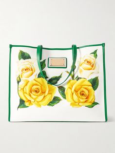 You can always expect the most romantic floral prints to adorn Dolce&Gabbana's designs, and this tote is no exception. Decorated with yellow roses, it's made from canvas in a structured shape outlined in leather trims and features the metal logo plaque. The roomy interior is lined in polka dots and has enough space for your water bottle, makeup kit and continental wallet. Luxury Floral Print Top Handle Bag, Designer Leather Bag With Floral Print, Designer Bags With Floral Print For Shopping, Luxury White Bags With Floral Print, Elegant Floral Print Tote Bag, Elegant Floral Print Shoulder Bag For Shopping, Elegant Floral Print Shopping Bag, Romantic Floral Print, Metal Logo