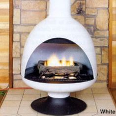 a large white vase sitting on top of a floor next to a fire place in a fireplace