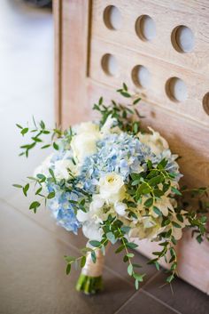 a bouquet of blue and white flowers sitting on top of a table