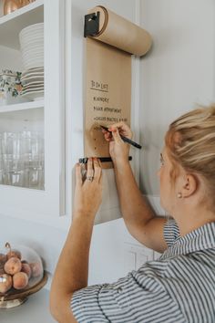 a woman is working on a wall hanging sign