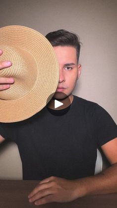 a man holding a straw hat over his face