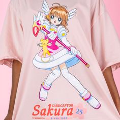 Celebrate 25 years of Cardcaptor Sakura with our Cardcaptor Sakura Ruffle T-Shirt Dress featuring a full front graphic of Sakura Kinomoto alongside Kero-chan, her Sealing Staff and the Cardcaptor Sakura 25th Anniversary logo. Complete with cute ruffles on the sleeve, this pretty pink t-shirt dress can also be worn as an oversized t-shirt, just size down! Oversized Fit Printed Details 100% Cotton Ruffled Detail Officially licensed Cardcaptor Sakura product ⓒC, ST/K, EP, N Model Sizes: Model 1: SMALL Model 2: LARGE