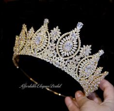 a close up of a person holding a tiara in their hand with black background