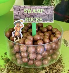 a bowl filled with lots of chocolate candies next to a sign that says swim rocks