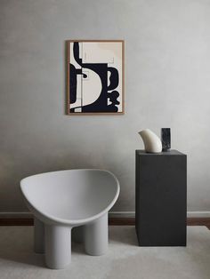 a white bath tub sitting next to a black and white vase on top of a table