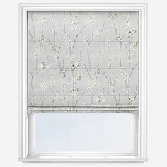 a window with a white flowered blind in front of it