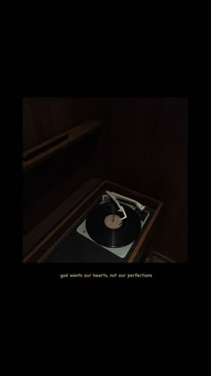 an old record player is sitting in the dark with its turntable on it's side