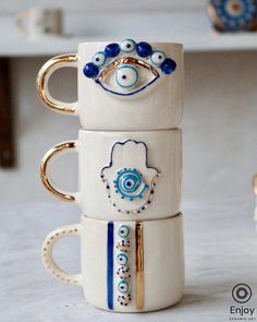 three coffee mugs are stacked on top of each other with evil eyes and eyeballs