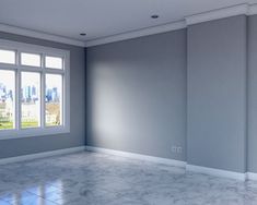 an empty room with white walls and marble flooring in front of a large window