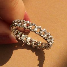 "Pave Curb Chain Eternity Ring ✨💎 Linked Together         #staychic, stay connected! ✨ * Heavy Rhodium plating over Sterling Silver * Top Grade 5A Cubic Zirconia Diamond Alternatives * Finished with a platinum look   👍 Recommendations * As an everyday ring * As a travel wedding band ✈ * As a gift for your soulmate ❤️   💎 Features       From the French word meaning \"to pave\", our silver band is paved with multiple round cubic zirconia. Inspired by chain links, this band brings a unique sparkle in day or nighttime. * CHAIN LINK DESIGN: The ring has contemporary feel to its design, makes perfect statement for any occasions for a person who likes latest trends. * CUBIC ZIRCONIA: Small CZ gem paved all around the ring, giving this ring an eye-catching silhouette. * ETERNITY BAND: This ring Luxury Diamond Accents Chain Promise Ring, Luxury Elegant Cubic Zirconia Chain Ring, Luxury Diamond Accented Promise Chain Ring, French Word, Silver Top, Everyday Ring, Word Meaning, Diamond Alternatives, Full Eternity Ring