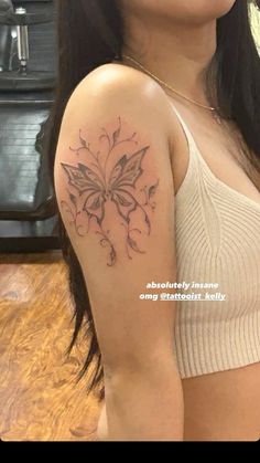 a woman with a butterfly tattoo on her arm and shoulder is looking at the camera