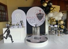 the table is set up with balloons and decorations for a soccer themed party or celebration