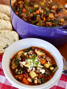 a bowl of soup with bread on the side