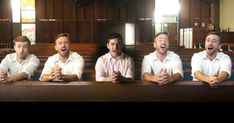 four men sitting at a table in front of pews with their mouths wide open