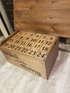 a wooden box with numbers on it sitting on the floor next to a bed frame