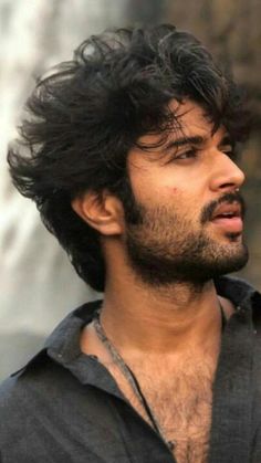 a close up of a man with long hair and beards looking off to the side