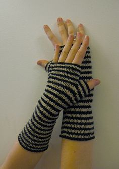 two hands wearing black and white striped arm warmers with one hand in the air