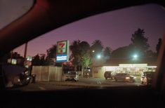 cars are parked in front of a gas station at night