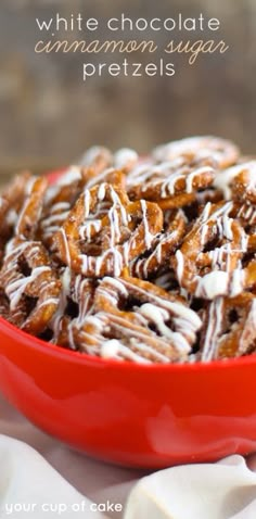 a red bowl filled with white chocolate cinnamon sugar pretzels on top of a table