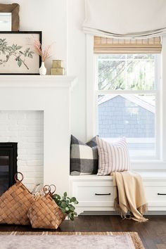 a living room filled with furniture and a fire place under a window next to a fireplace