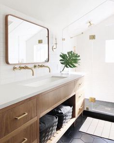 a bathroom with a large mirror, sink and wooden cabinetry in it's center