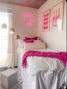 a bed room with a neatly made bed next to a window and pictures on the wall