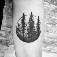 a black and white photo of trees in a circle tattoo on the right calf leg