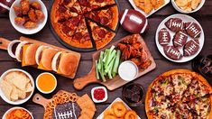 a table topped with pizzas and other foods next to football themed snacks on plates