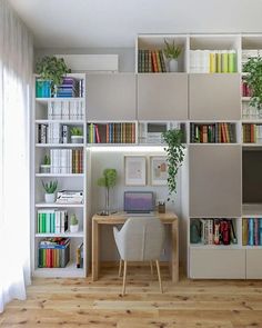 an office with bookshelves, desk and computer on the shelf next to it