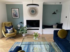 a living room filled with furniture and a flat screen tv mounted to a wall above a fireplace