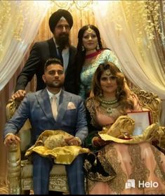 a man and two women are posing for a photo in front of a gold throne