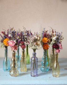 several vases with flowers in them sitting on a table