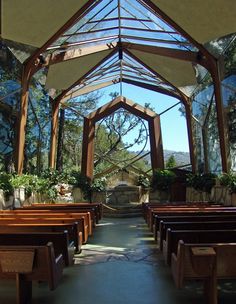 the inside of a church with wooden pews and plants growing in it's roof