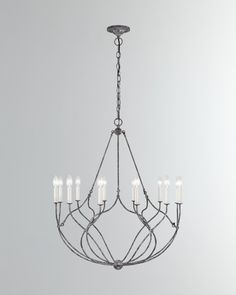 an iron chandelier with eight candles hanging from the center, on a gray background