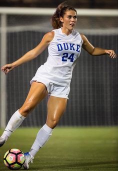 a female soccer player in action on the field during a game against university of duke