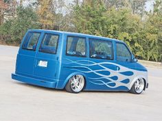 a blue van with flames painted on it's side parked in a parking lot