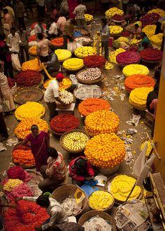 an overhead view of people selling flowers and other items at a flower market in india