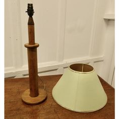 a lamp shade next to a wooden pole on a table